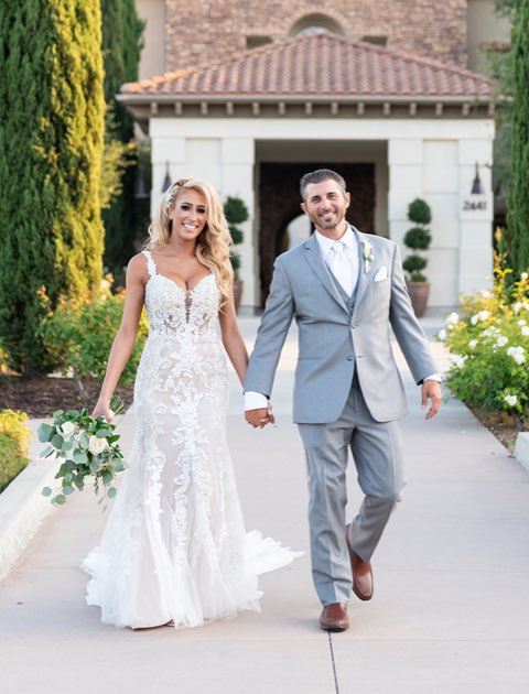 Blonde bride and groom are walking near the church